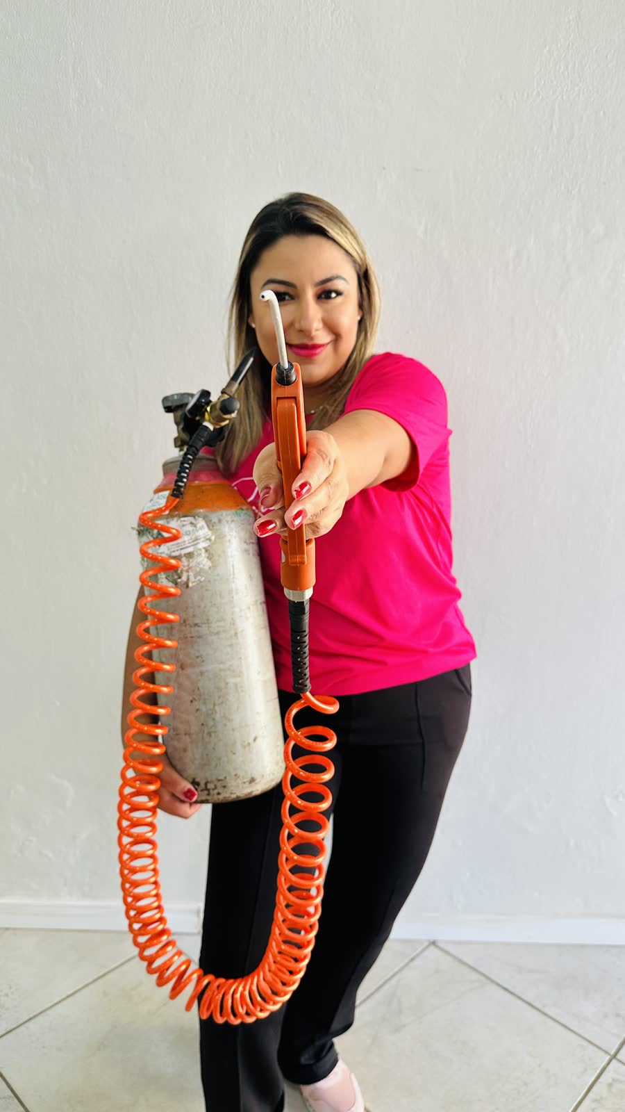Rafaela Palskuski segurando o cilindro de gás hélio e apontando a pistola de inflar balões