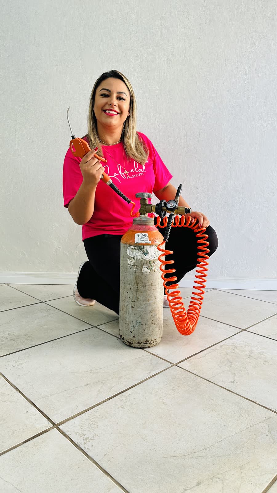 Rafaela sorrindo ao lado do cilindro de gás hélio e das ferramentas de inflar balões