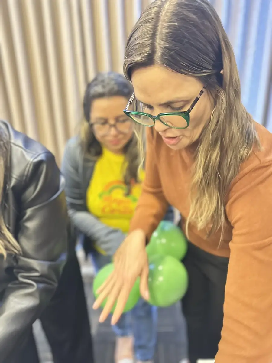 Aluna montando cluster de balões prata